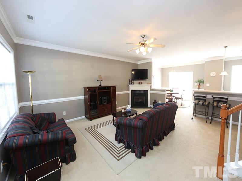 2715 Andover Glen Road Raleigh, NC 27604 - Photo 2 of 16 a living room with furniture a fireplace and a flat screen tv