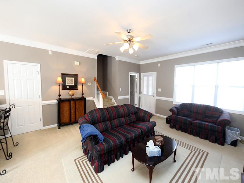 2715 Andover Glen Road Raleigh, NC 27604 - Photo 4 of 16 a living room with furniture a chandelier and a flat screen tv