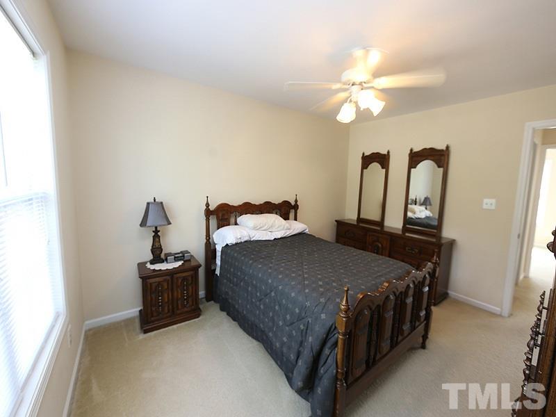 2715 Andover Glen Road Raleigh, NC 27604 - Photo 9 of 16 a bedroom with a bed and a chandelier