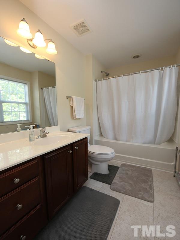 2715 Andover Glen Road Raleigh, NC 27604 - Photo 10 of 16 a bathroom with a double vanity sink toilet and a mirror