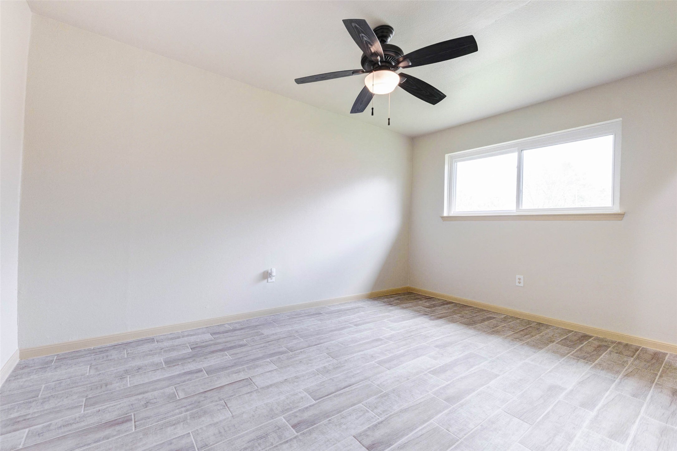 5319 Ridgestone Street Houston, TX 77053 - Photo 18 of 26 an empty room with wooden floor fan and windows