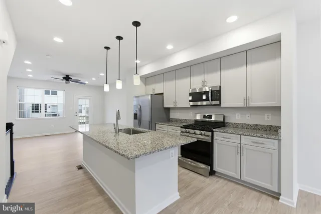 a kitchen with stainless steel appliances granite countertop a stove a sink and a refrigerator