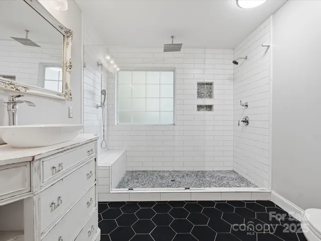 a bathroom with a granite countertop sink a toilet and shower