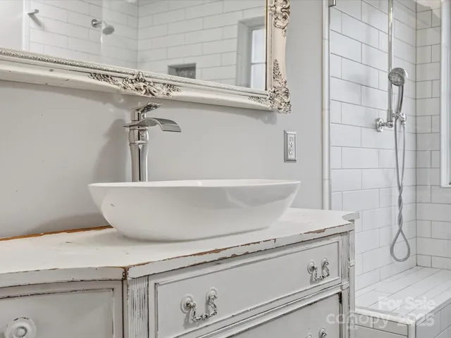 a view of a sink with wooden cabinets