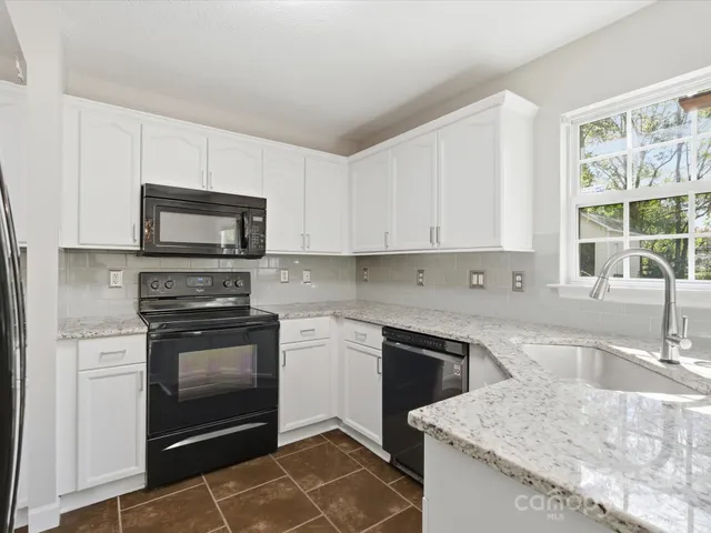 a kitchen with stainless steel appliances granite countertop a sink stove and microwave