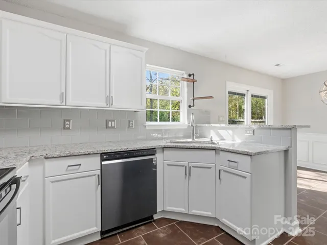 a kitchen with white cabinets and sink
