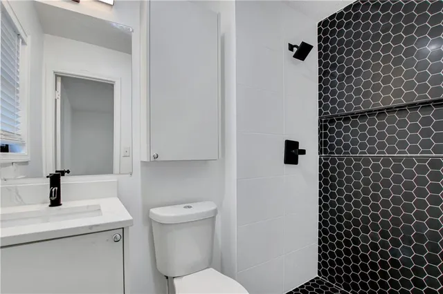 a bathroom with a sink a toilet and shower