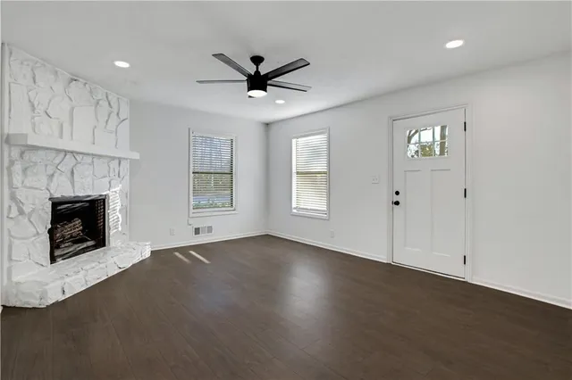 a view of an empty room with a fireplace and a window