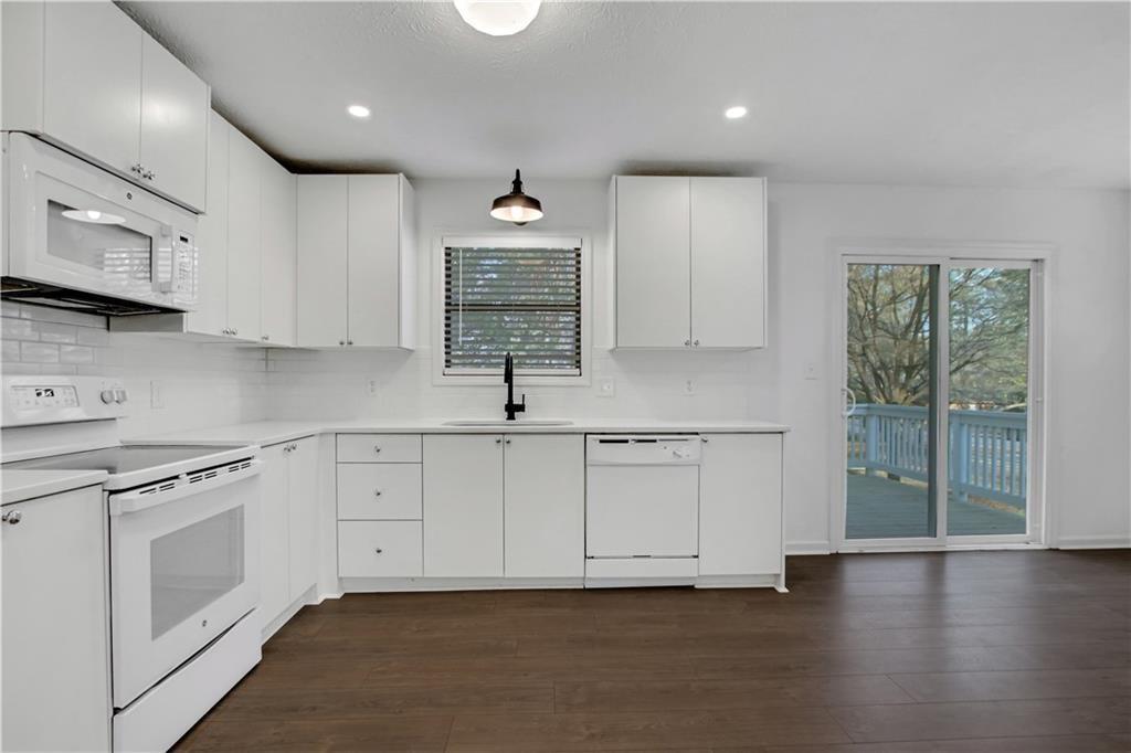 1000 Mathews Court, Unit B Smyrna, GA 30080 - Photo 16 of 42 a kitchen with granite countertop white cabinets and white appliances
