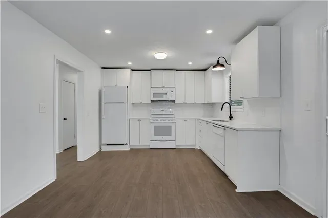 a kitchen with white cabinets and stainless steel appliances