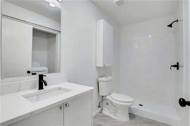 a bathroom with a sink a toilet and shower