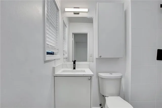 a bathroom with a sink toilet and mirror