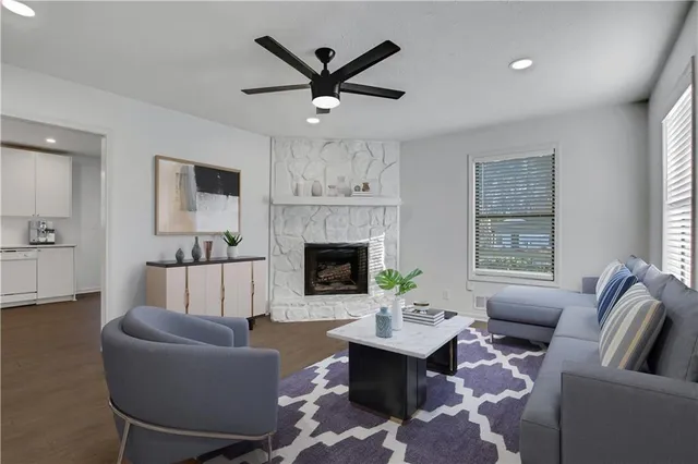 a living room with furniture a fireplace and a large window