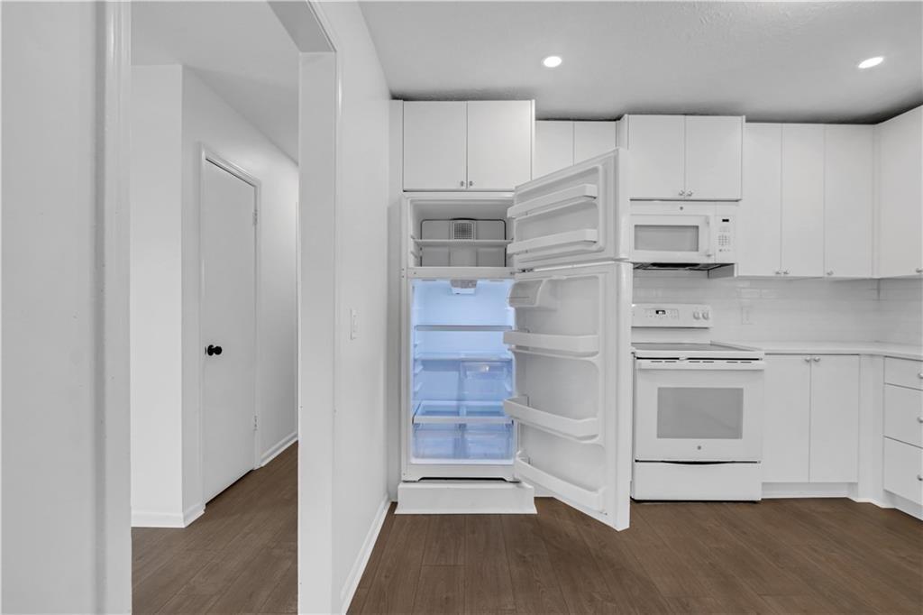 1000 Mathews Court, Unit B Smyrna, GA 30080 - Photo 38 of 42 a kitchen with kitchen island white cabinets and stainless steel appliances