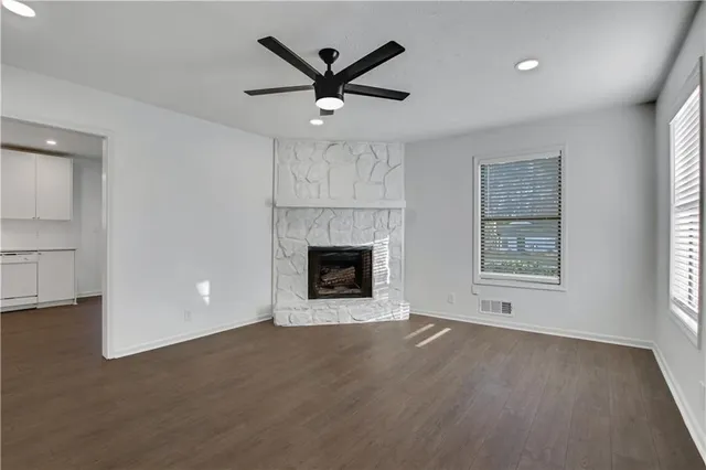 an empty room with windows and fireplace