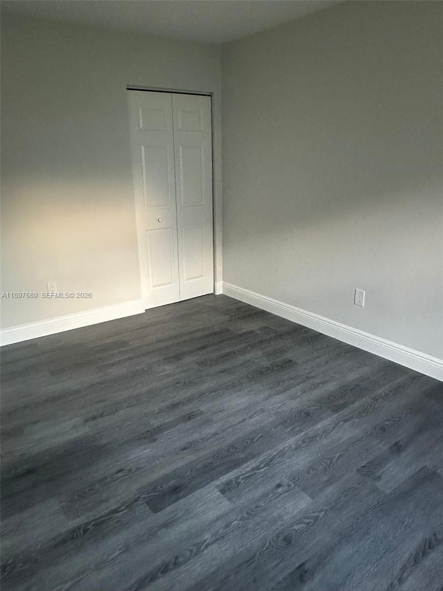 855 Northeast 209th Street, Unit 10334 Miami, FL 33179 - Photo 11 of 38 a view of an empty room with wooden floor
