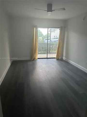 an empty room with wooden floor and balcony