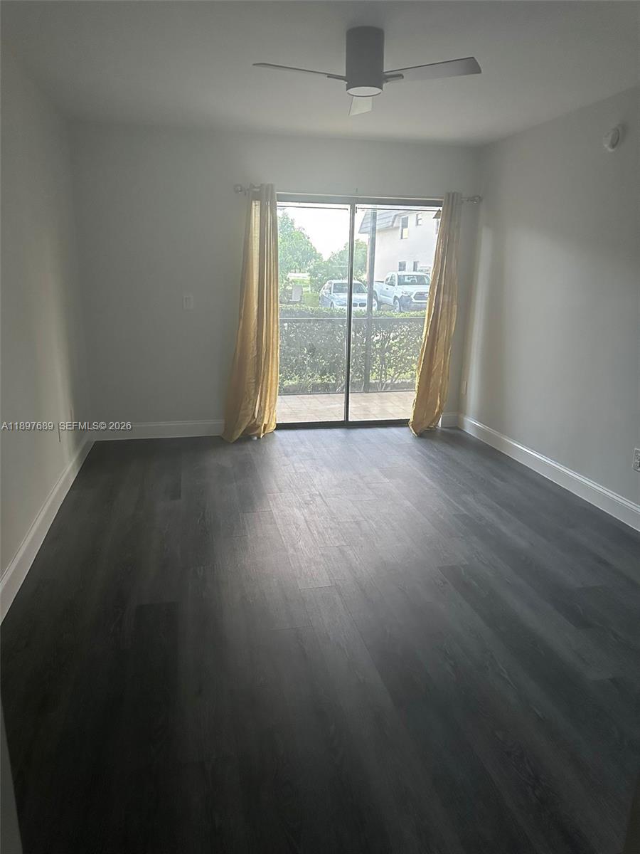 855 Northeast 209th Street, Unit 10334 Miami, FL 33179 - Photo 12 of 38 an empty room with wooden floor and balcony