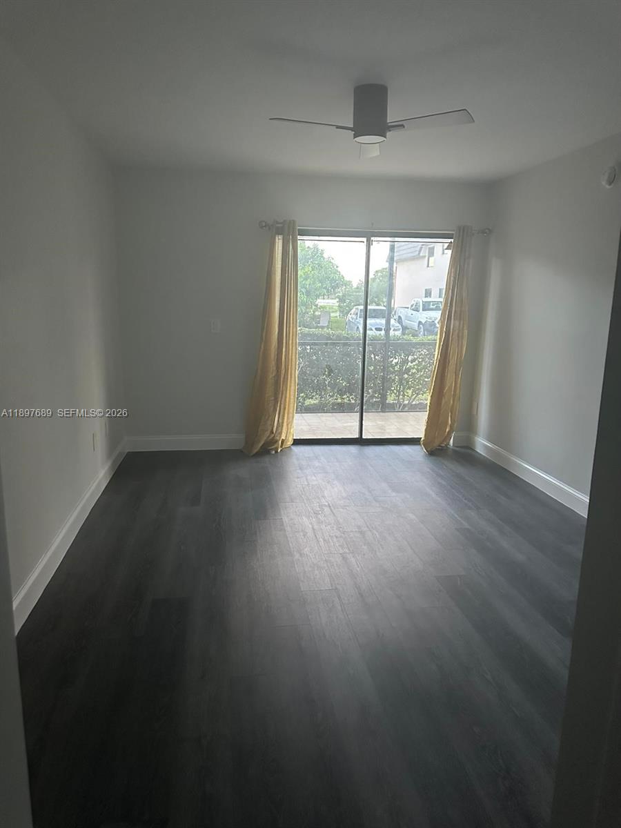 855 Northeast 209th Street, Unit 10334 Miami, FL 33179 - Photo 14 of 38 a view of an empty room with wooden floor and a window