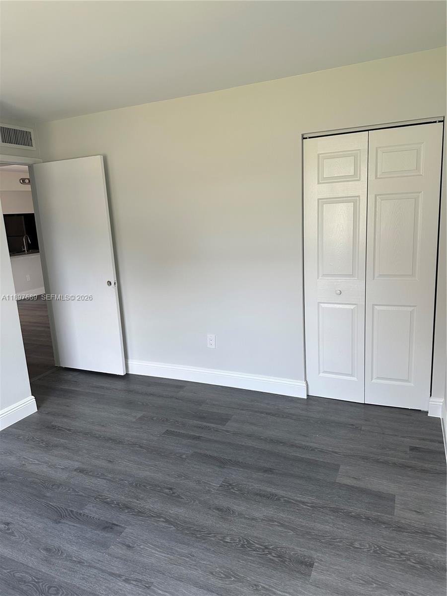 855 Northeast 209th Street, Unit 10334 Miami, FL 33179 - Photo 31 of 38 a view of an empty room with wooden floor and a window