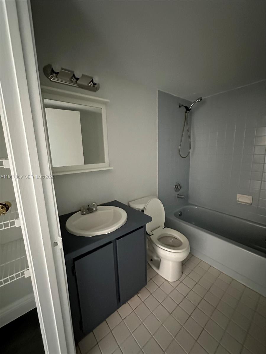 855 Northeast 209th Street, Unit 10334 Miami, FL 33179 - Photo 33 of 38 a bathroom with a sink a toilet a mirror and shower