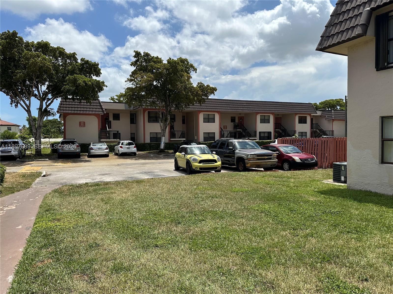 855 Northeast 209th Street, Unit 10334 Miami, FL 33179 - Photo 36 of 38 a front view of house with yard and car parked