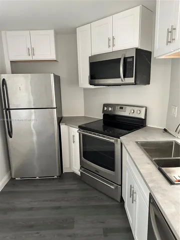 a kitchen with a microwave and a white cabinets