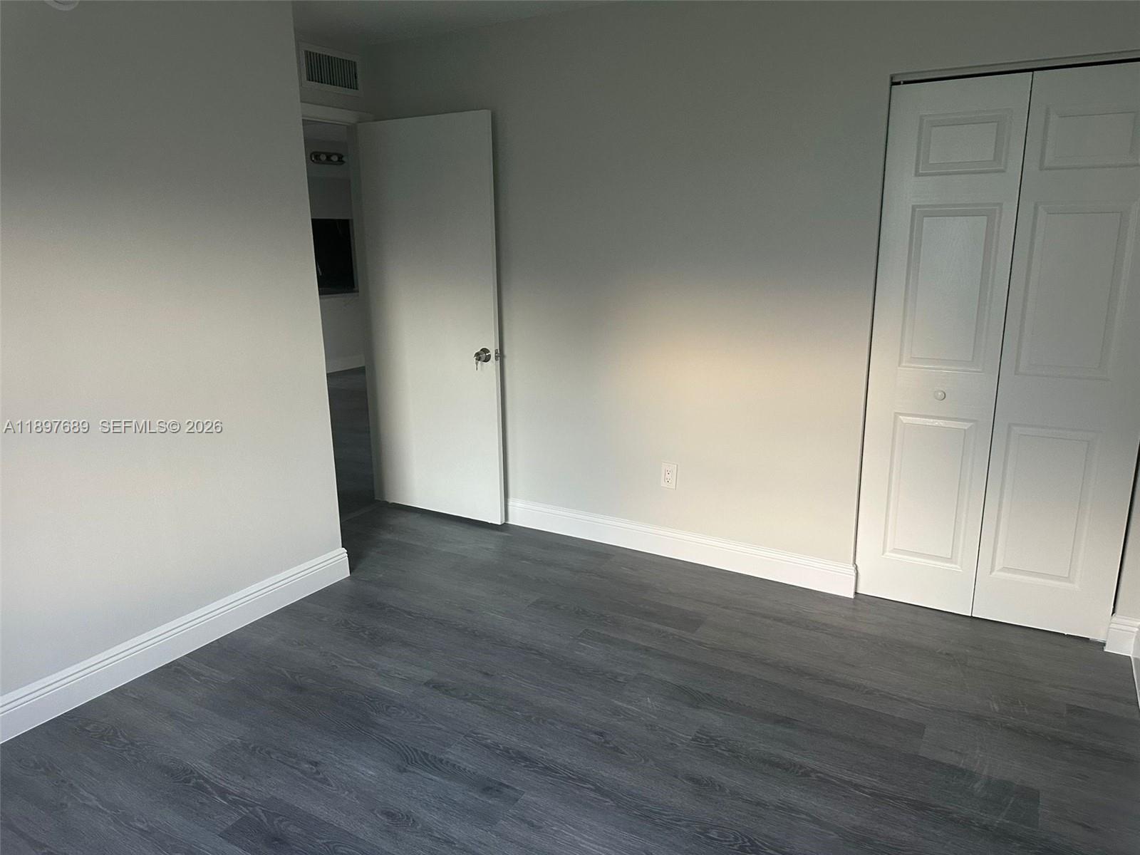 855 Northeast 209th Street, Unit 10334 Miami, FL 33179 - Photo 8 of 38 a view of an empty room with wooden floor