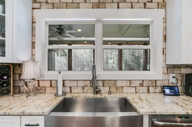 a large kitchen with sink refrigerator and microwave