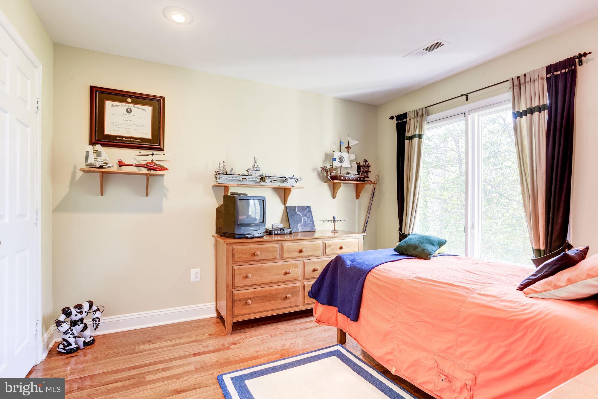 1300 Pavilion Club Way Reston, VA 20194 - Photo 19 of 30 a bedroom with a bed and a flat tv screen on dresser