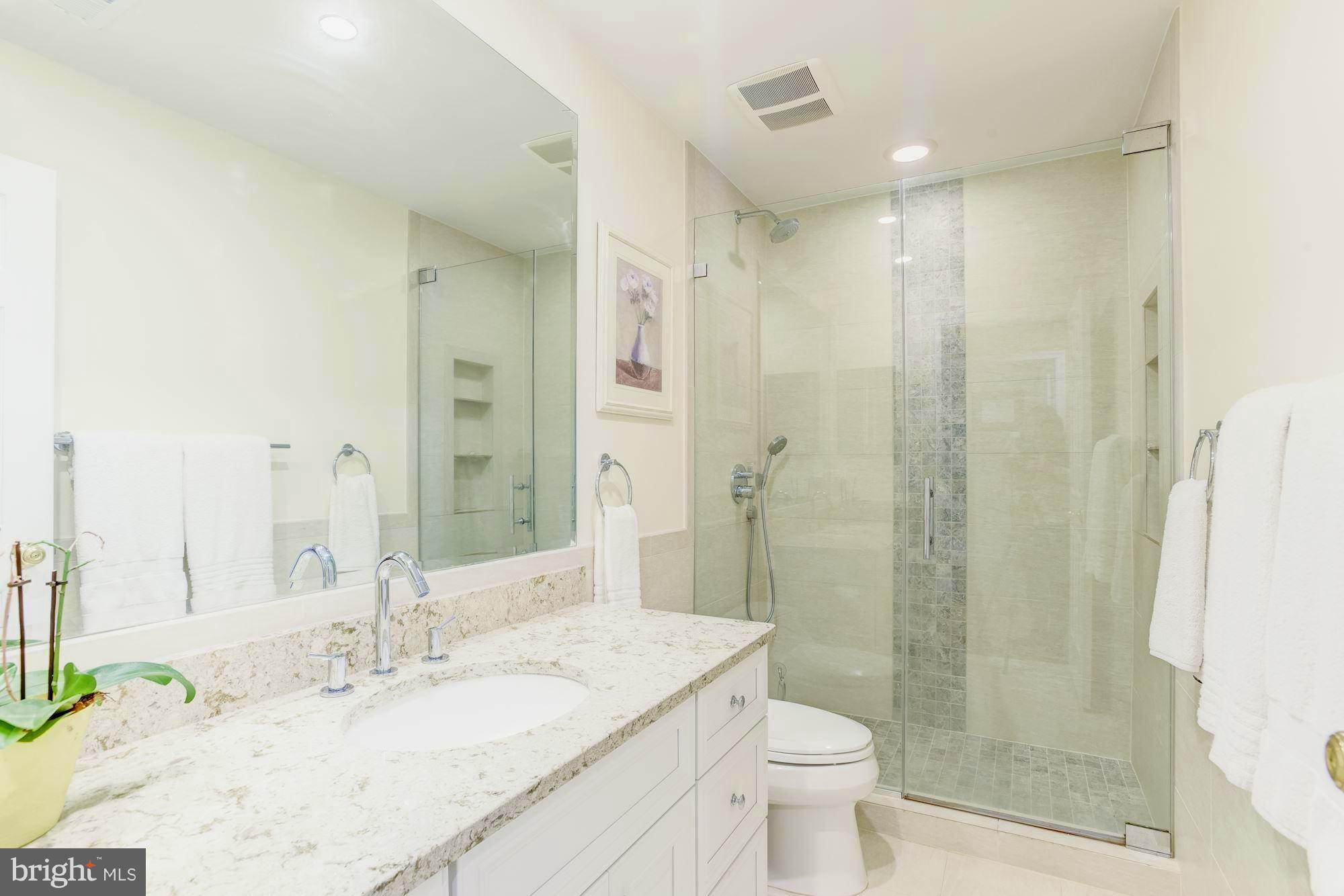 1300 Pavilion Club Way Reston, VA 20194 - Photo 20 of 30 a bathroom with a granite countertop sink toilet and shower