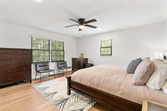 a bedroom with a bed and a dresser next to a window