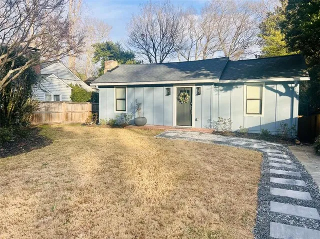 a view of a house with a yard and pathway