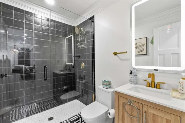 a bathroom with a sink a toilet and shower