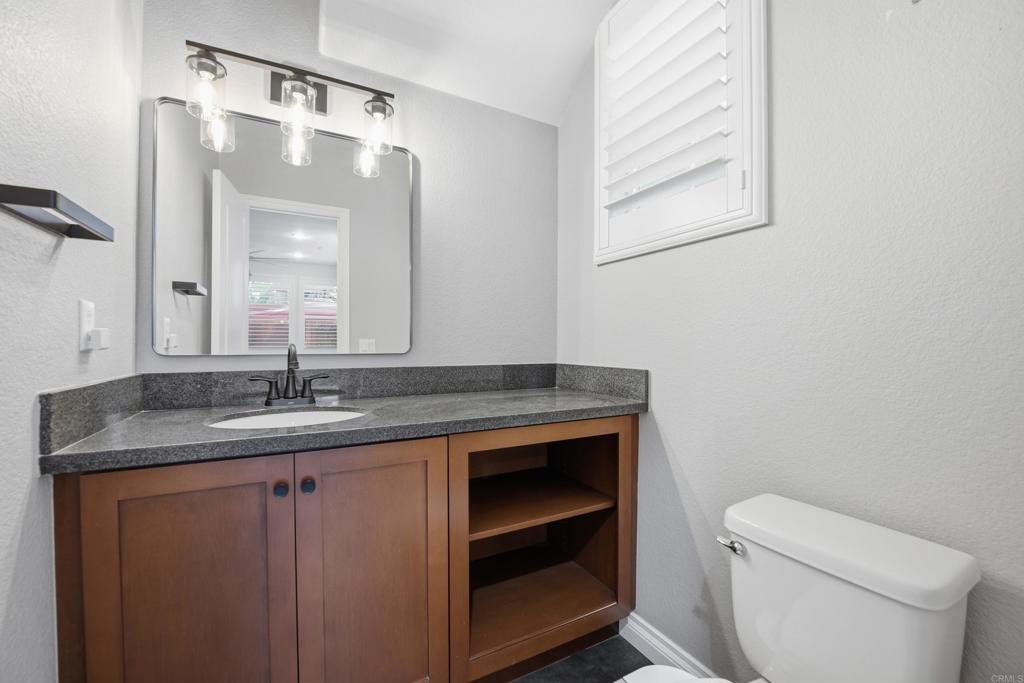 2284 Durango Way, Unit 200 San Marcos, CA 92078 - Photo 13 of 39 a bathroom with a granite countertop sink a toilet and a mirror