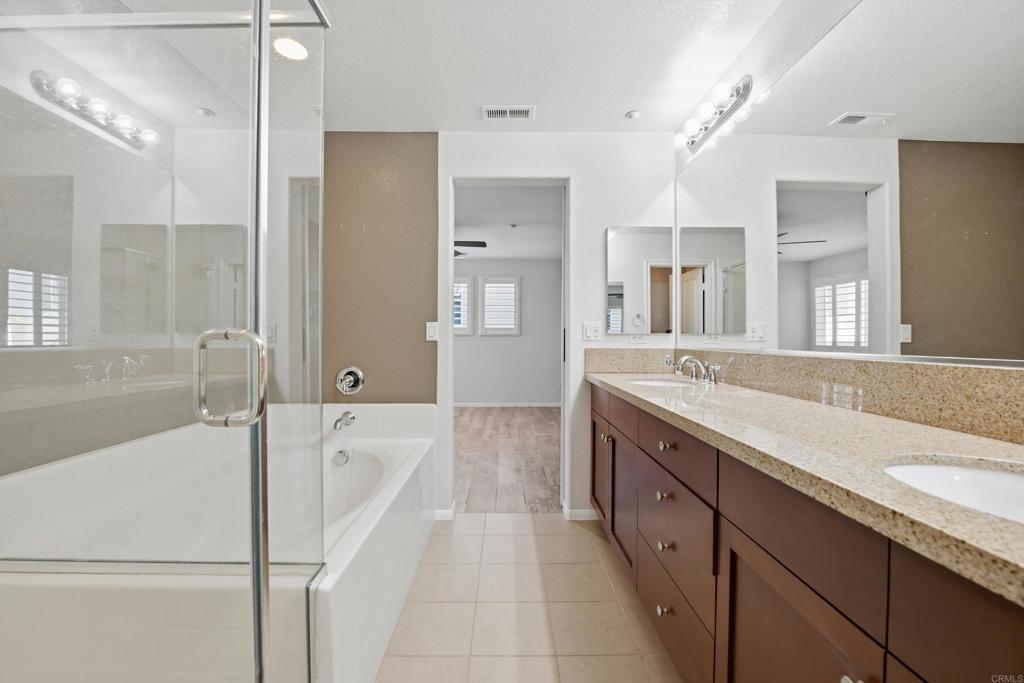 2284 Durango Way, Unit 200 San Marcos, CA 92078 - Photo 17 of 39 a spacious bathroom with a granite countertop sink a toilet a mirror and shower
