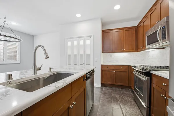 a kitchen with granite countertop a sink and stainless steel appliances