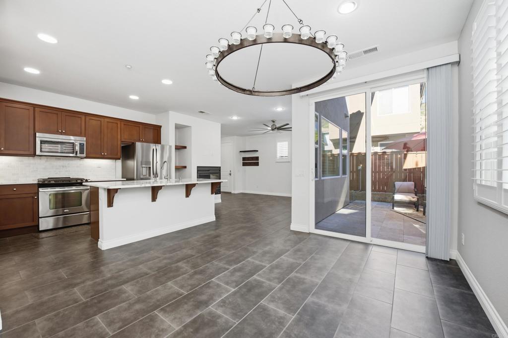 2284 Durango Way, Unit 200 San Marcos, CA 92078 - Photo 9 of 39 a large kitchen with stainless steel appliances granite countertop a stove a sink and a refrigerator