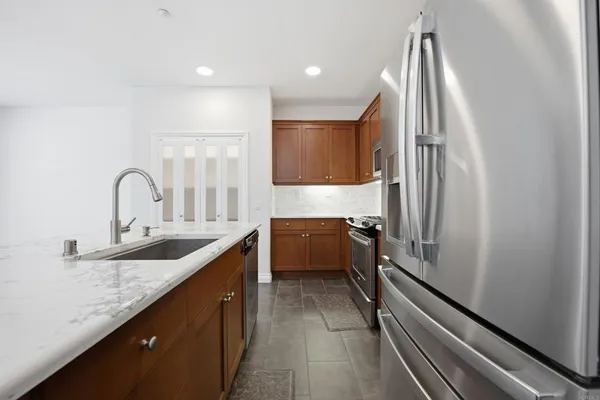 a dining room with stainless steel appliances granite countertop a table and chairs