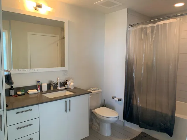 a bathroom with a sink a toilet a shower and a mirror