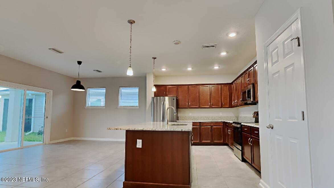 12032 Bridgehampton Road Jacksonville, FL 32218 - Photo 3 of 13 a kitchen with stainless steel appliances granite countertop a refrigerator a sink and a stove