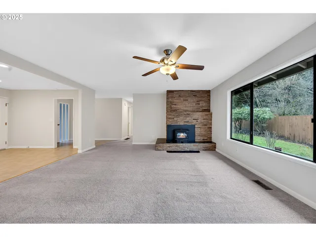 a view of an empty room with a fireplace and a large window