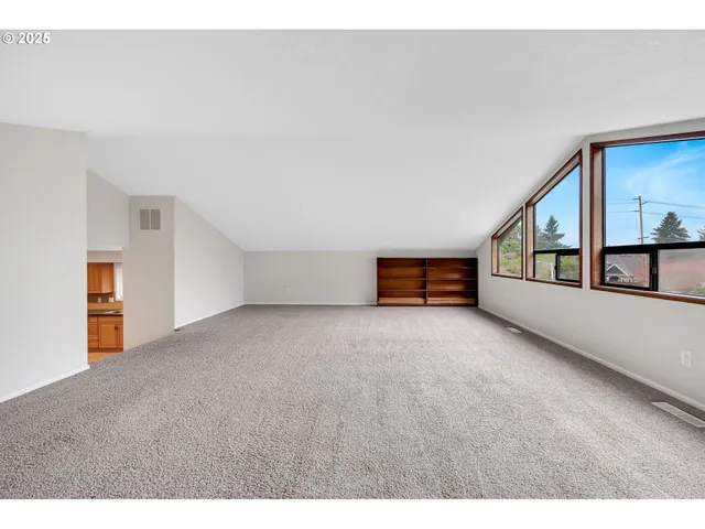 a view of an empty room with kitchen