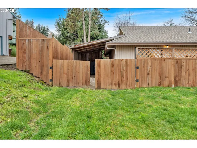 a view of backyard with potted plants and wooden fence
