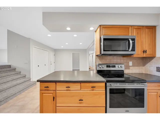 a kitchen with granite countertop a stove and a microwave