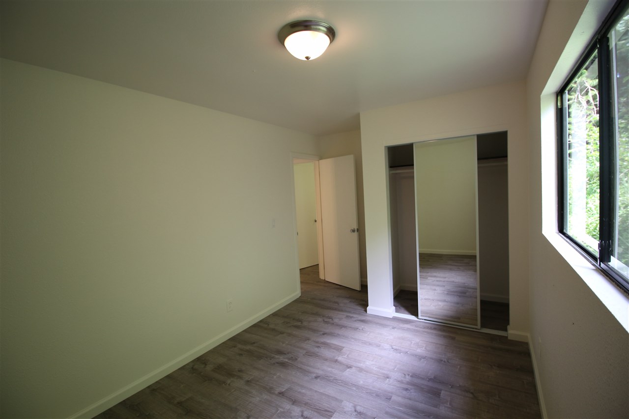 1000 Kauhikoa Road Haiku, HI 96708 - Photo 12 of 17 an empty room with wooden floor and windows