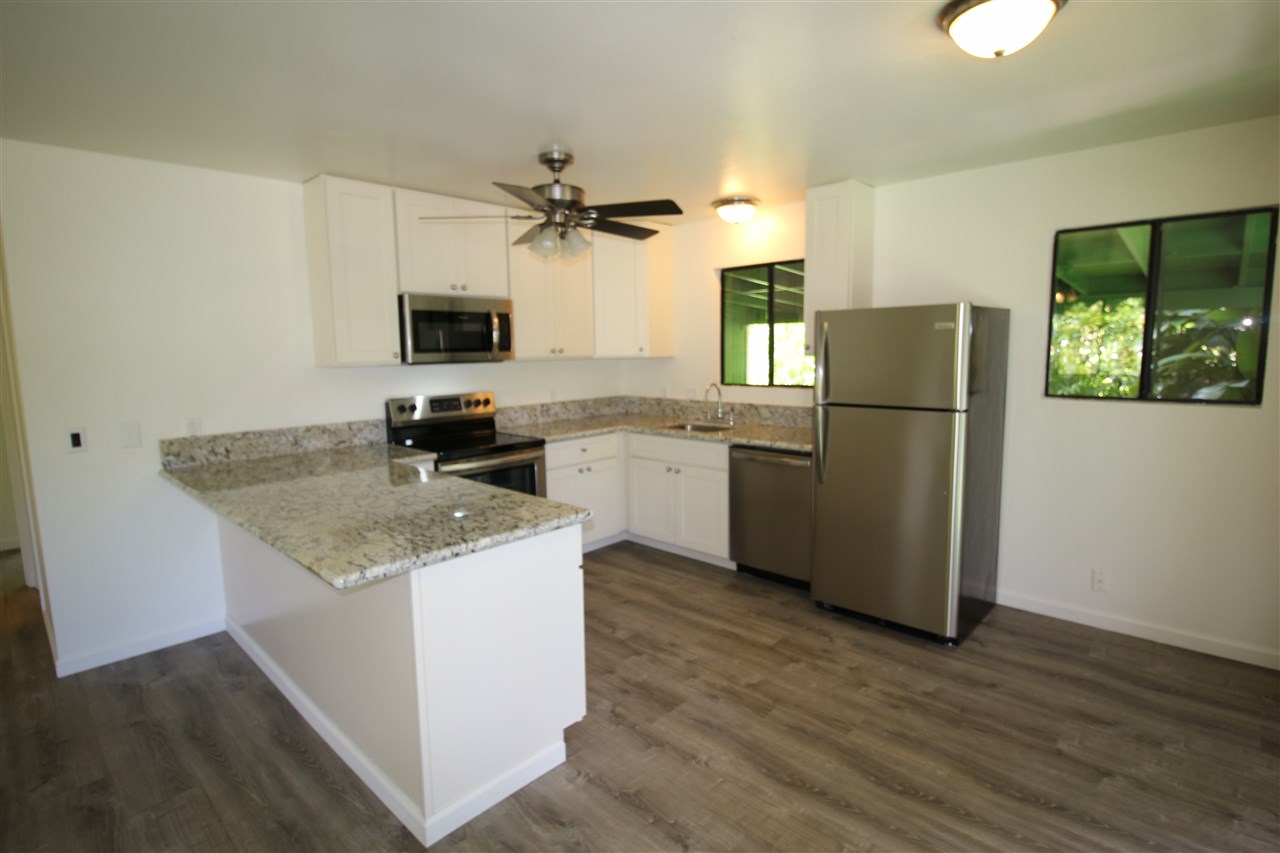 1000 Kauhikoa Road Haiku, HI 96708 - Photo 5 of 17 a kitchen with a refrigerator a sink and a stove top oven