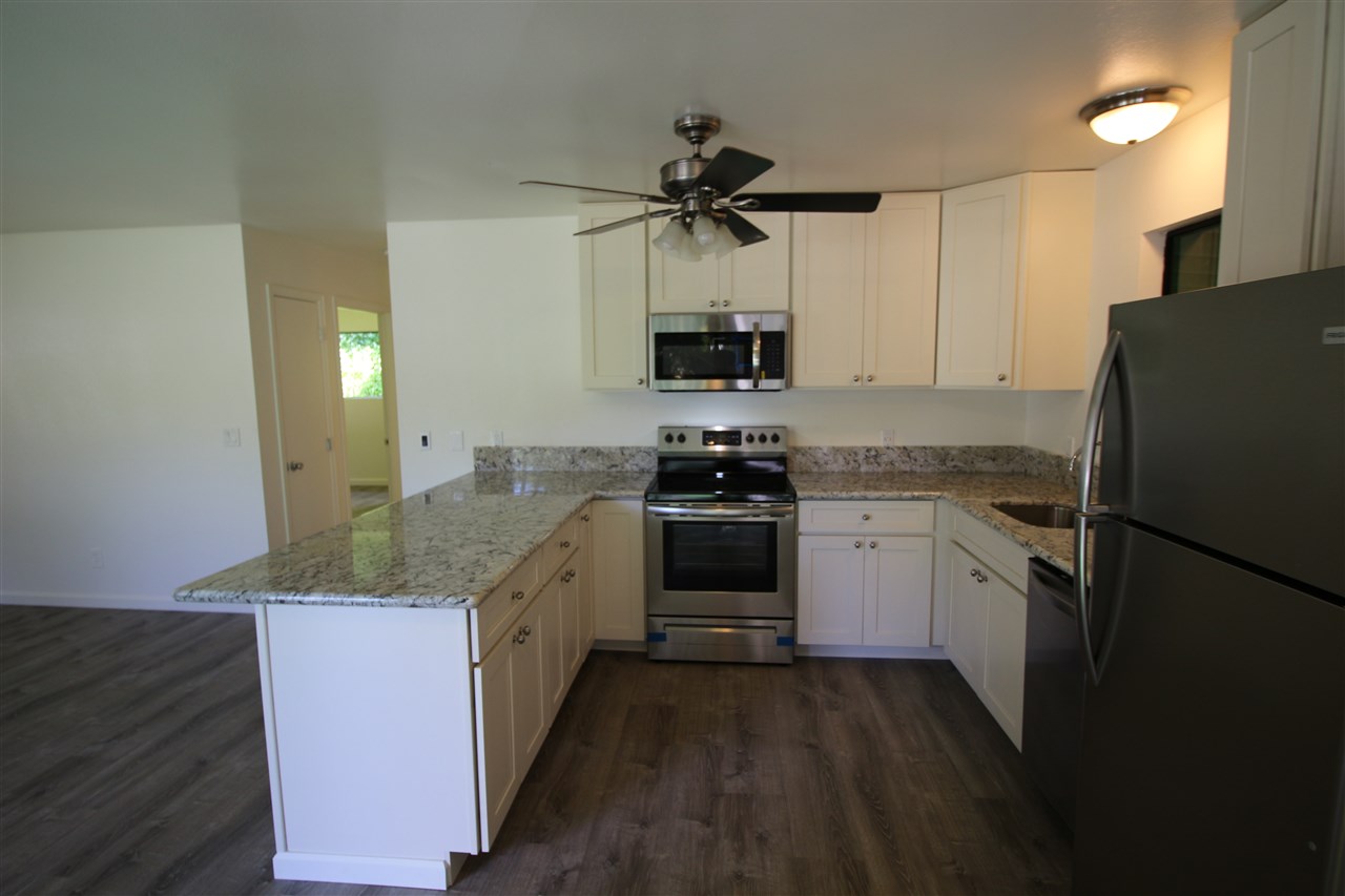 1000 Kauhikoa Road Haiku, HI 96708 - Photo 6 of 17 a kitchen with stainless steel appliances granite countertop a refrigerator a stove a sink and a microwave