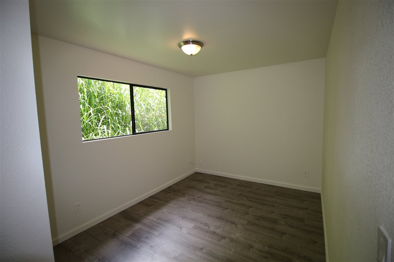1000 Kauhikoa Road Haiku, HI 96708 - Photo 10 of 17 an empty room with wooden floor and windows