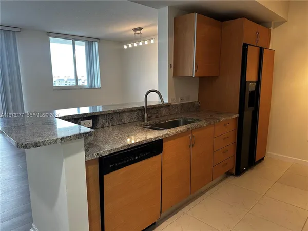 a kitchen with stainless steel appliances granite countertop a sink and a refrigerator
